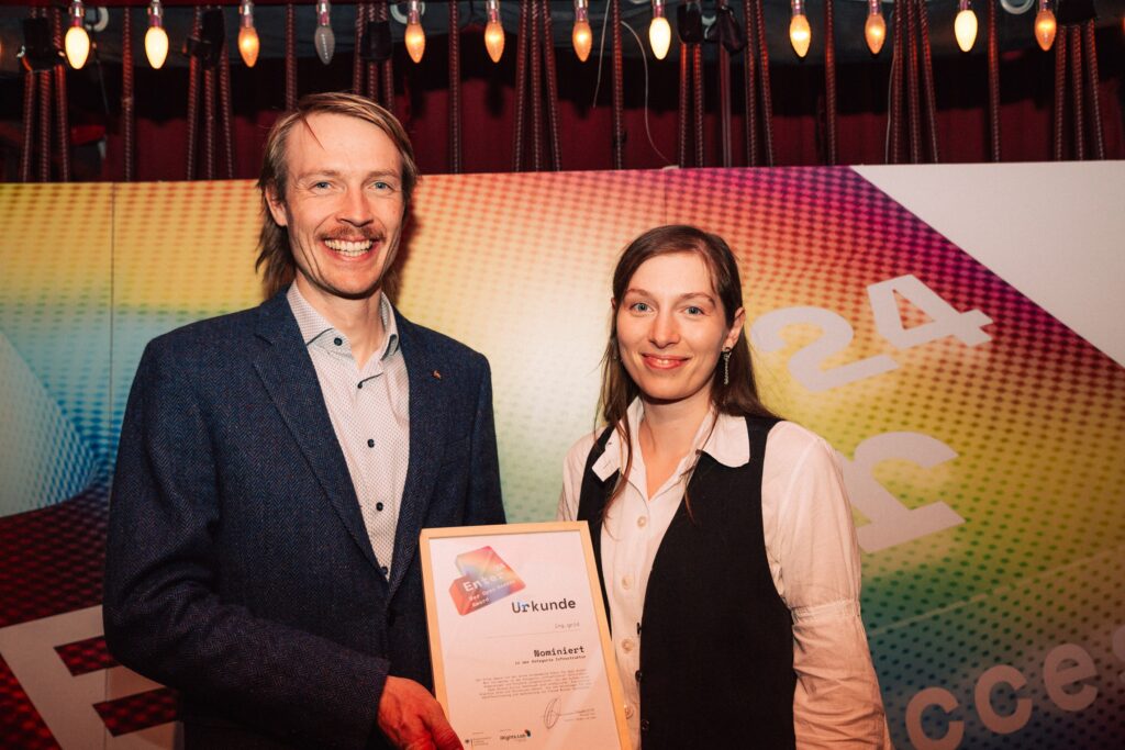 Image of Kevin Logan and Michaela Leštáková holding the shortlist certificate for the Enter Award.